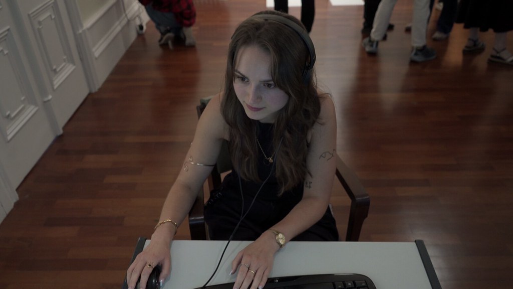 A visitor with headphones on, playing the duel at the exhibition