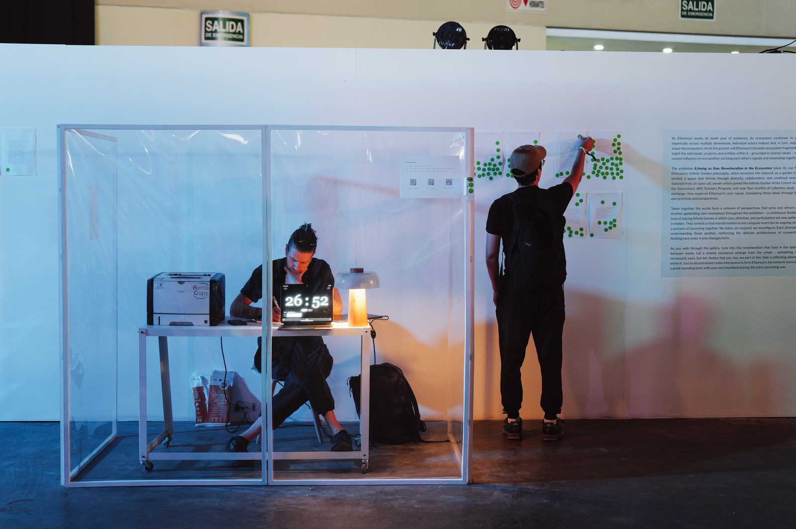 Reinforcement.exe performance with poet writing inside the cube and audience voting on the wall